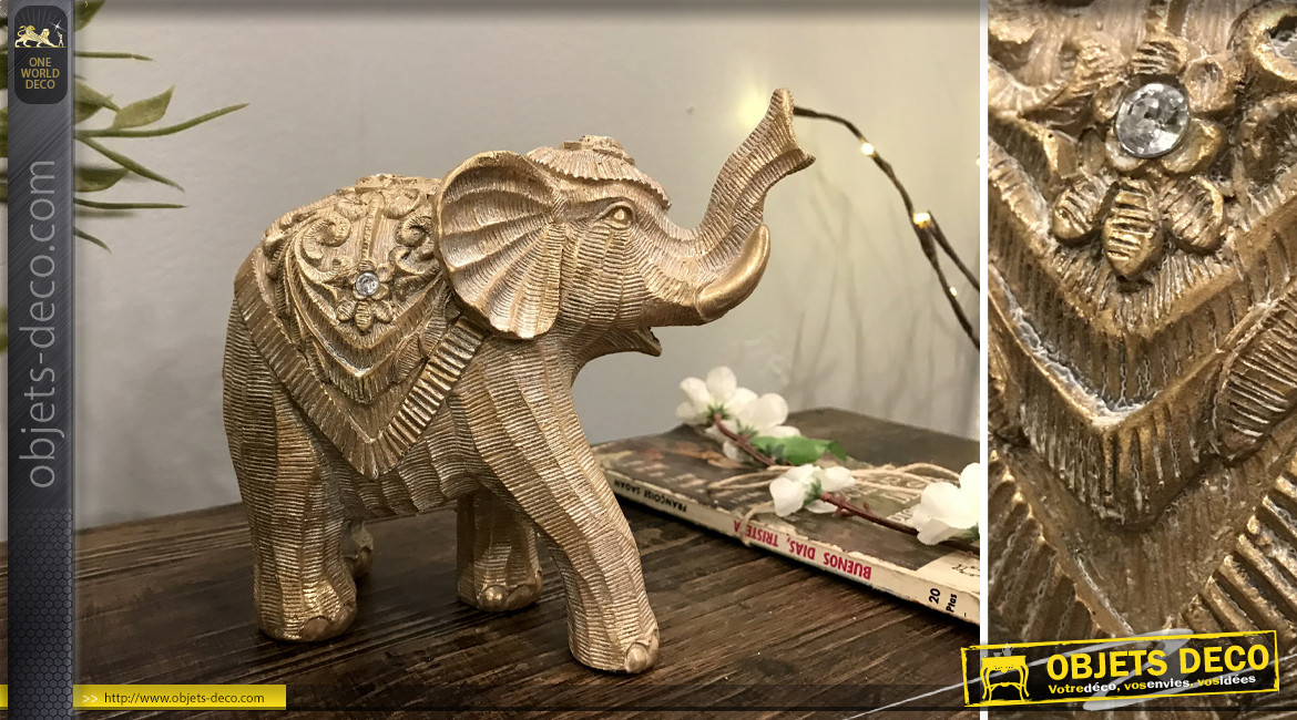 Statuette d'un éléphant en résine effet bois sculpté, reflets dorés sur fond brossé, 17cm