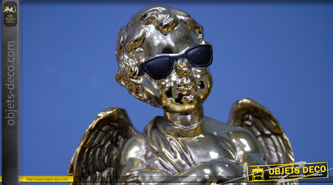 Représentation d'un angelot sur socle, en résine finition dorée effet chromé, ambiance contemporaine, lunettes noires sur les yeux, 29cm